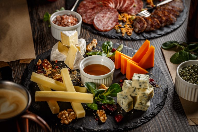 Appetizer table with antipasto snacks. Cheese and meat variety board over wooden background