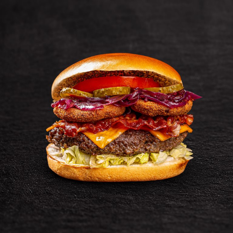 Delicious homemade beef burgers with bacon on black background